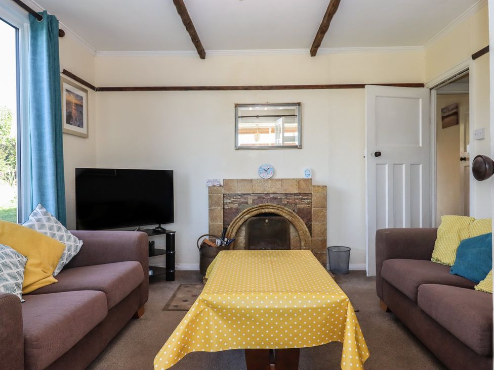 A living room with a television and sofas at Highdown in Bigbury on Sea near Modbury