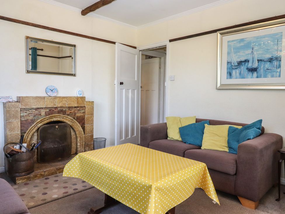 A living room with a fireplace and sofa at Highdown Bigbury on Sea near Modbury