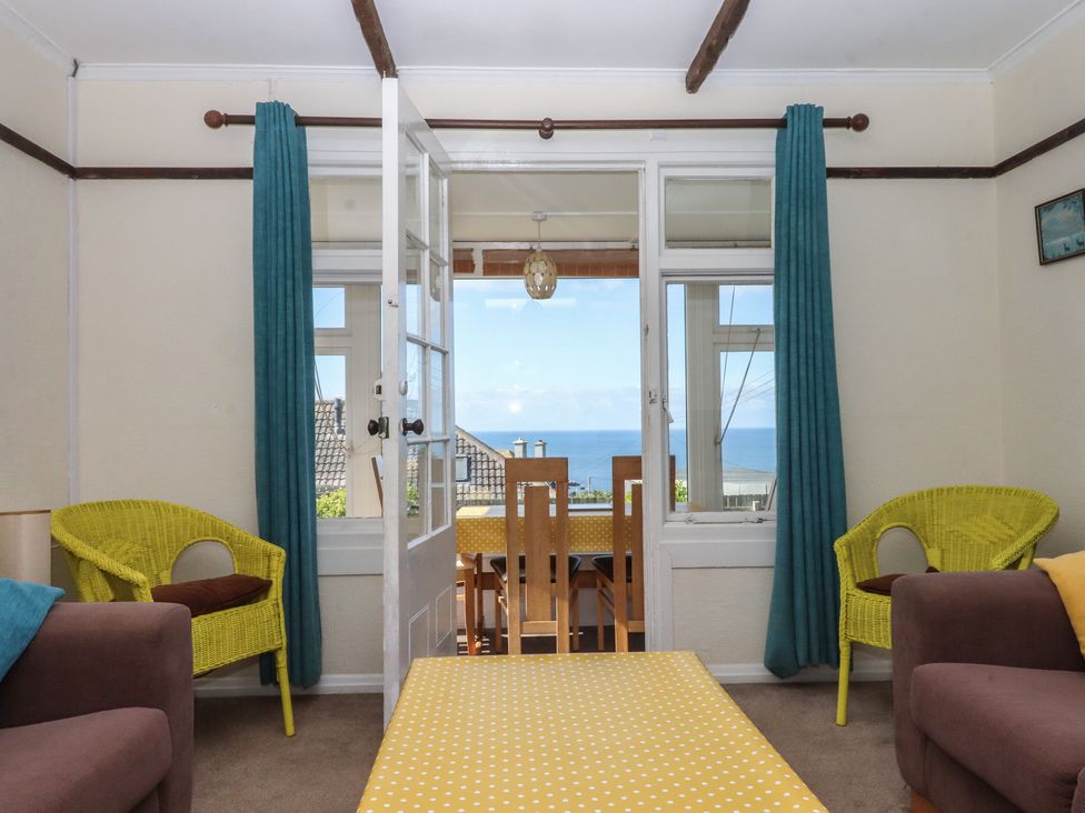 A living room with a dining table and chairs at Highdown in Bigbury on Sea near Modbury