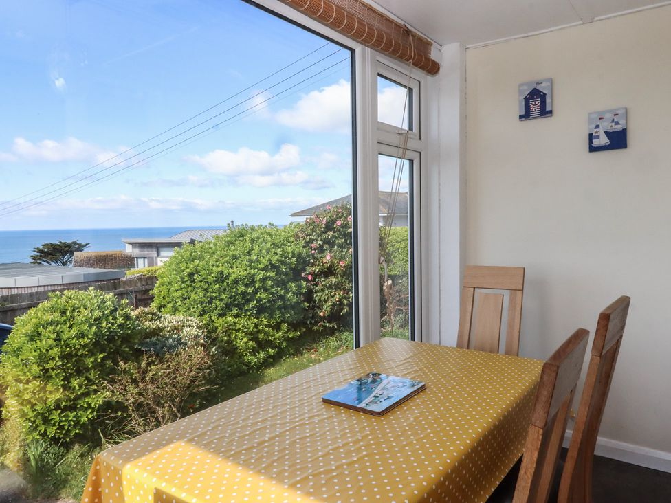 A dining room with a table and chairs at Highdown in Bigbury on Sea near Modbury