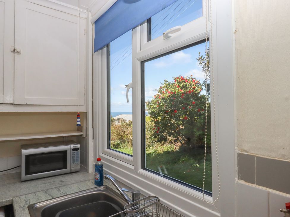 A kitchen with a window and a microwave at Highdown in Bigbury on Sea near Modbury