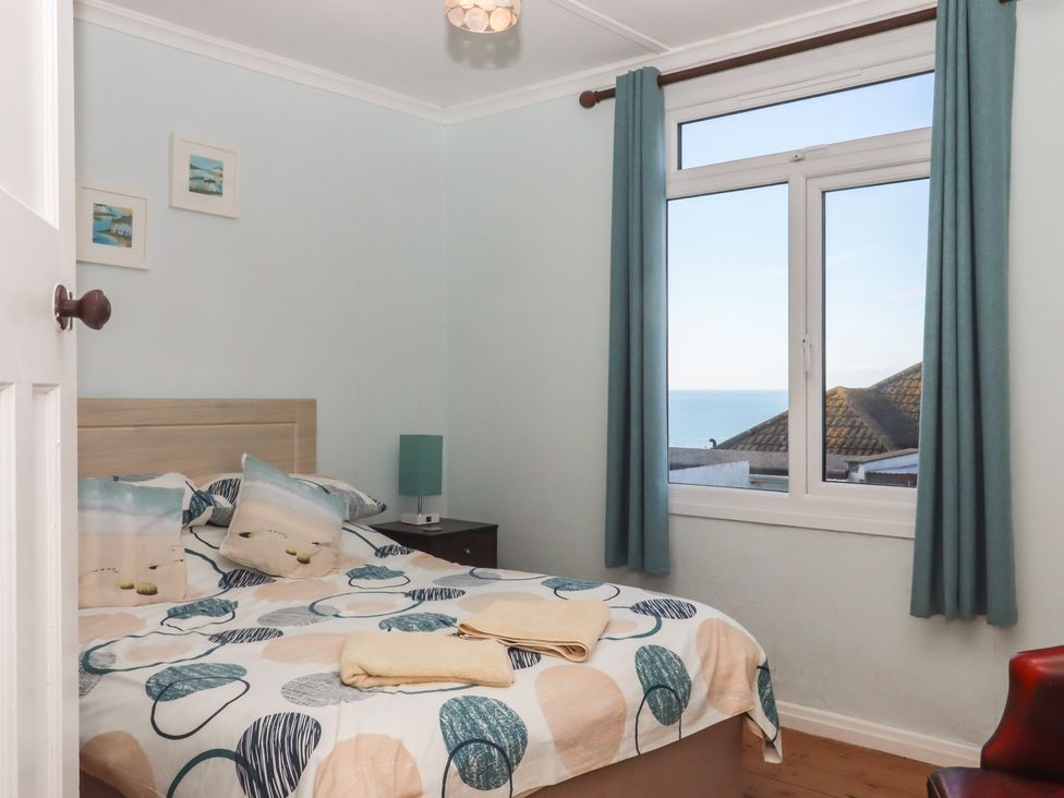 A bedroom with a bed and a window at Highdown in Bigbury on Sea near Modbury