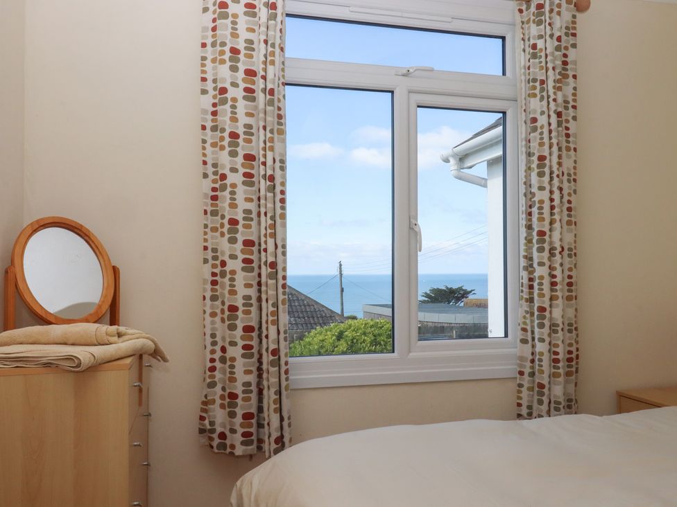 A bedroom with a window view at Highdown in Bigbury on Sea near Modbury