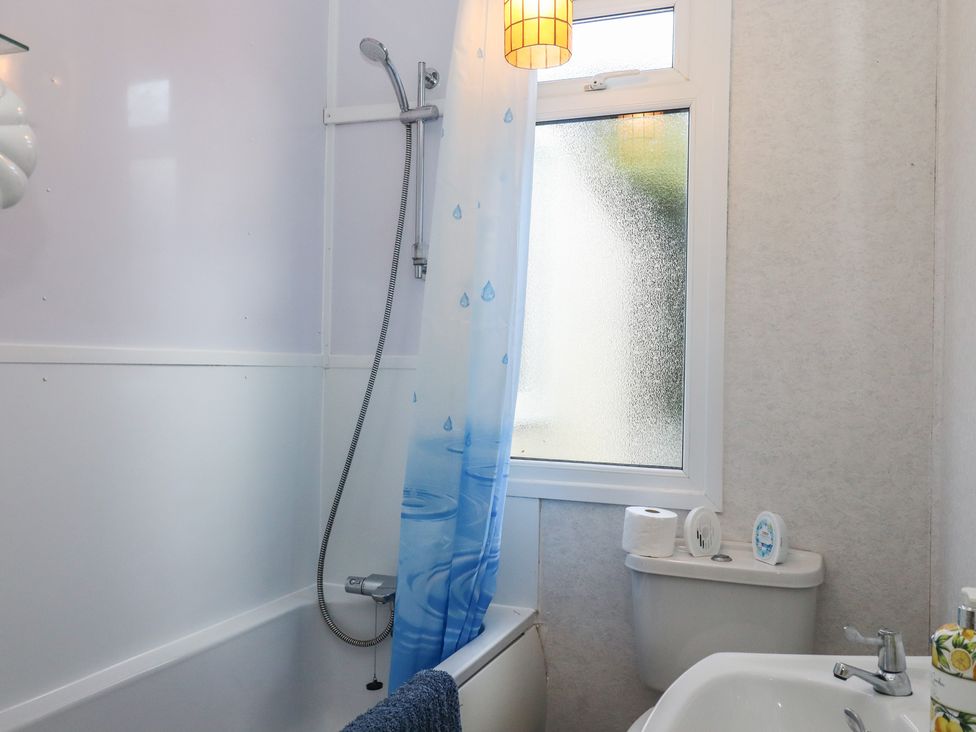 A bathroom with a shower, bathtub, and toilet at Highdown in Bigbury on Sea near Modbury