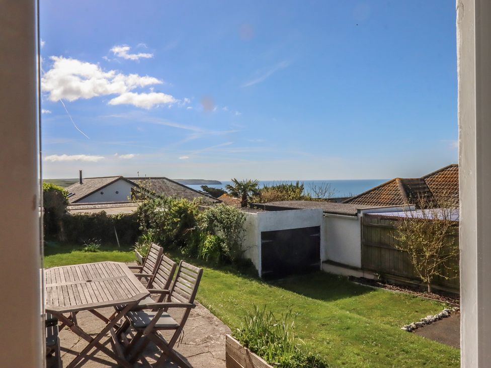 A garden with a table and chairs overlooking the sea at Highdown Bigbury on Sea near Modbury
