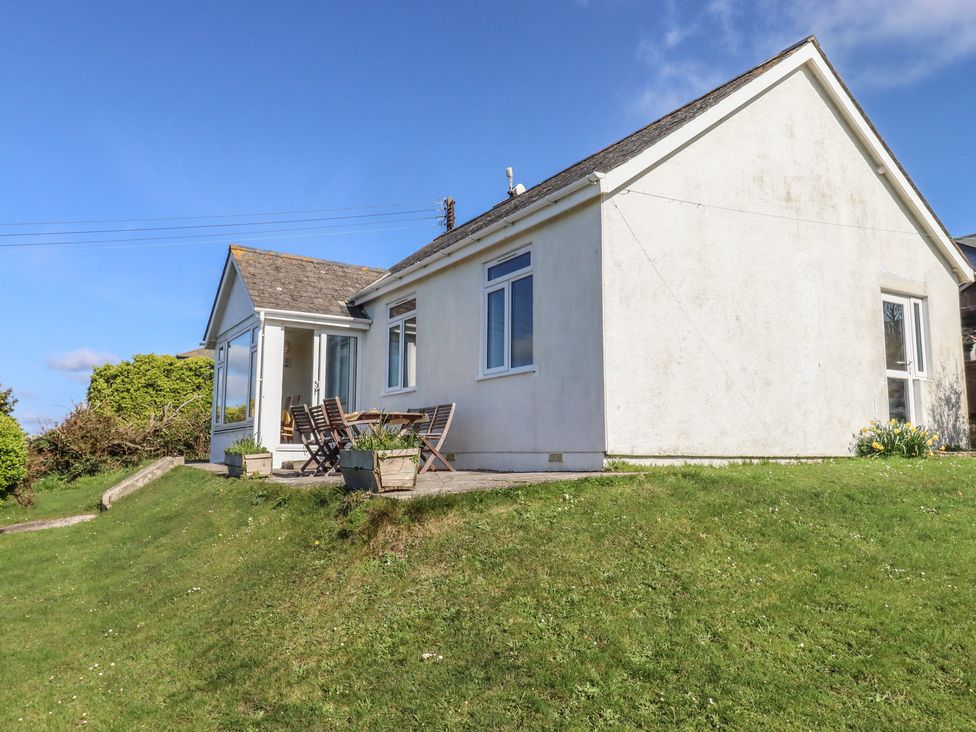 A house with windows and a seating area at Highdown in Bigbury on Sea near Modbury