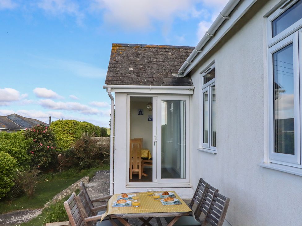 An outdoor dining area with a table and chairs at Highdown Bigbury on Sea near Modbury