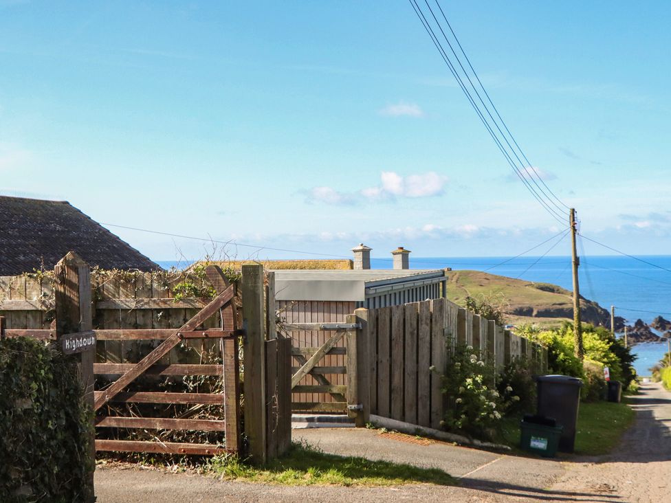 A coastal view with a fence and gate at Highdown in Bigbury on Sea near Modbury