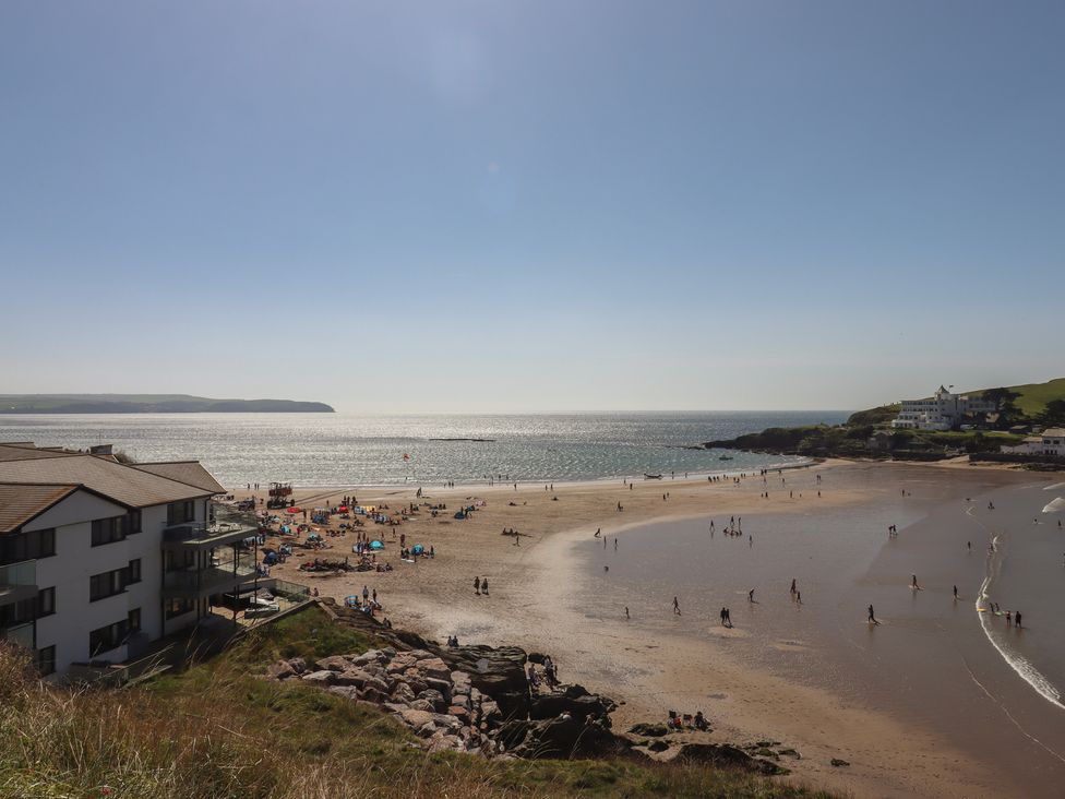 A beach with people and buildings near the ocean at Highdown in Bigbury on Sea near Modbury