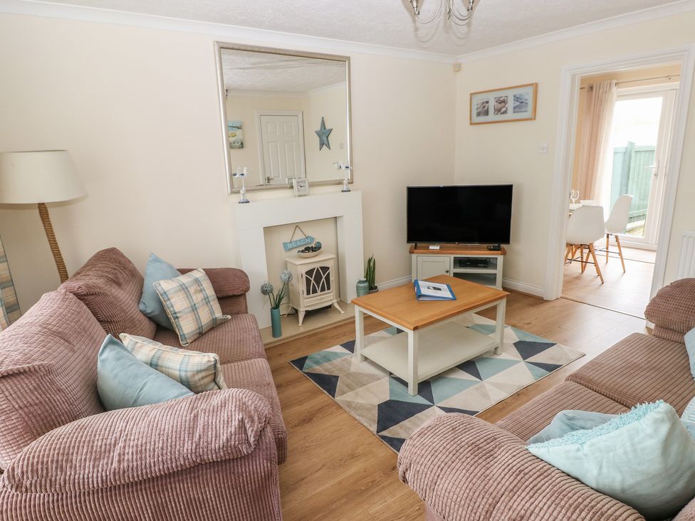 A living room with a television and sofa at Sandyhill House in Saundersfoot