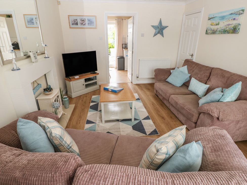 A living room with a sofa and television at Sandyhill House in Saundersfoot