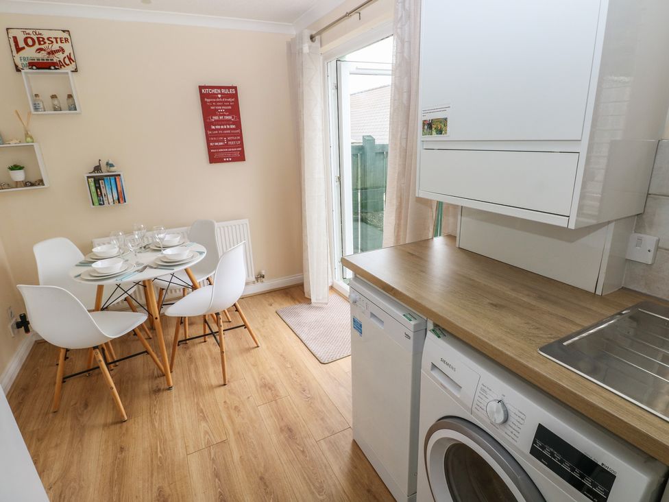 A kitchen with a dining table and chairs at Sandyhill House in Saundersfoot