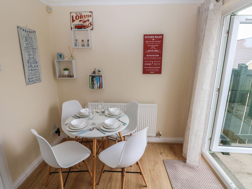 A dining room with a table set for dinner at Sandyhill House in Saundersfoot