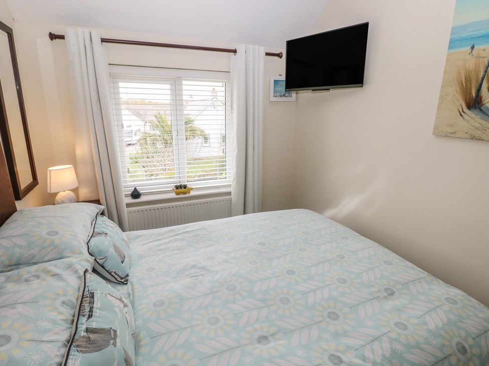 A bedroom with a bed and a television at Sandyhill House in Saundersfoot