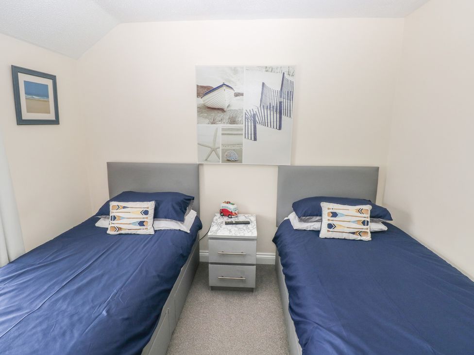 A bedroom with twin beds and a nightstand at Sandyhill House in Saundersfoot