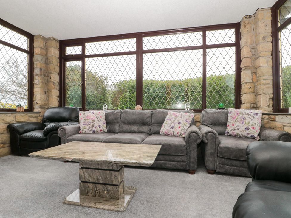 A conservatory with a sofa and coffee table at Seacrest Lodge in Scarborough