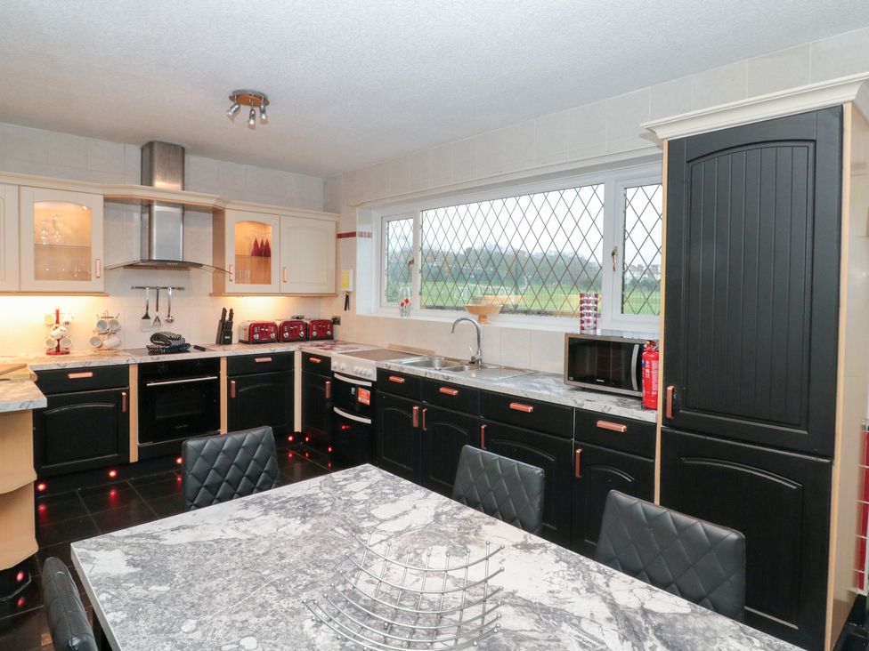 A kitchen with a sink, oven, and table at Seacrest Lodge in Scarborough