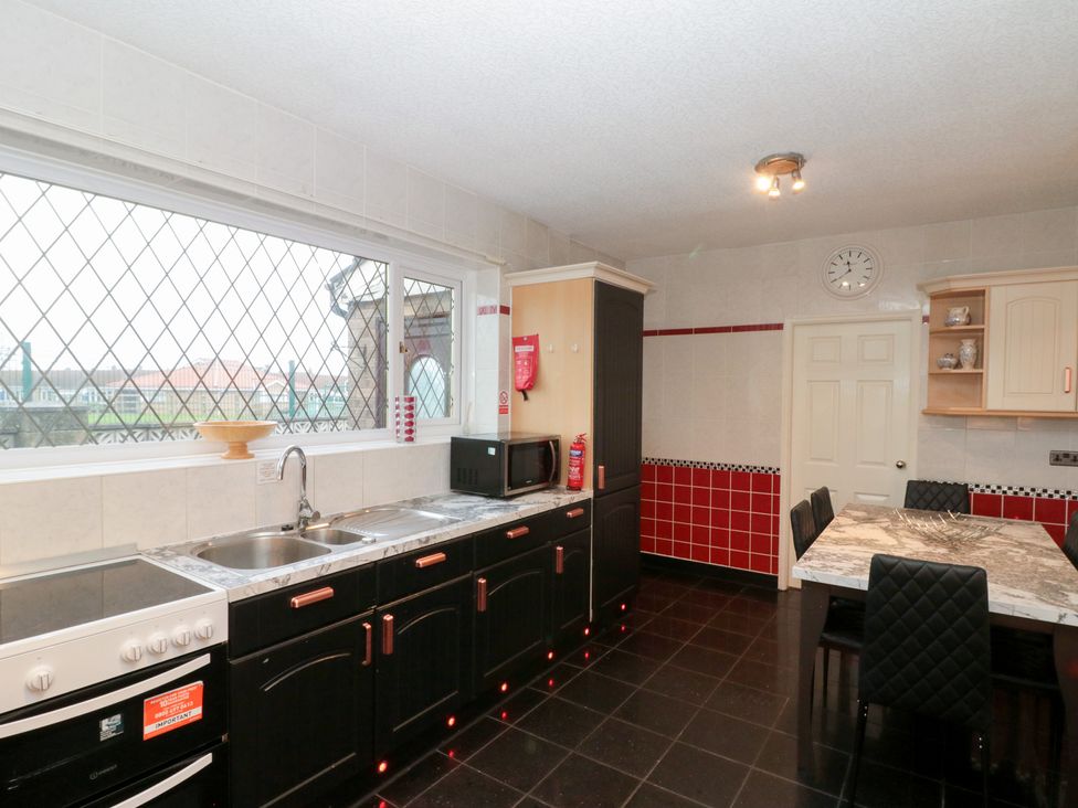 A kitchen with a sink and dining table at Seacrest Lodge in Scarborough