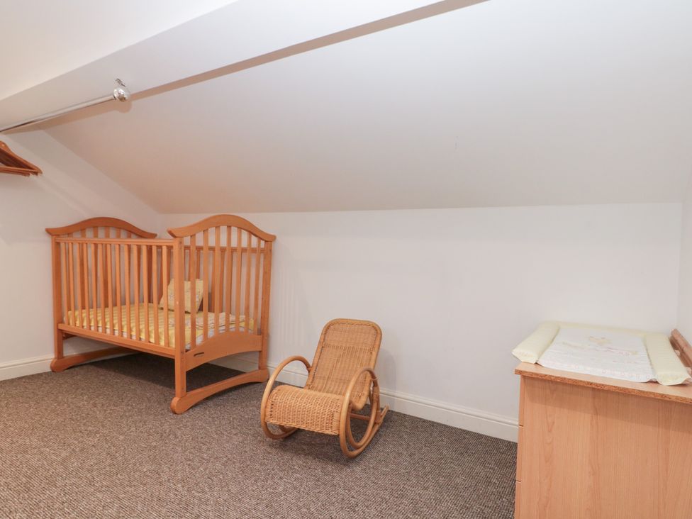 A nursery with a crib and a rocking chair at Seacrest Lodge Scarborough