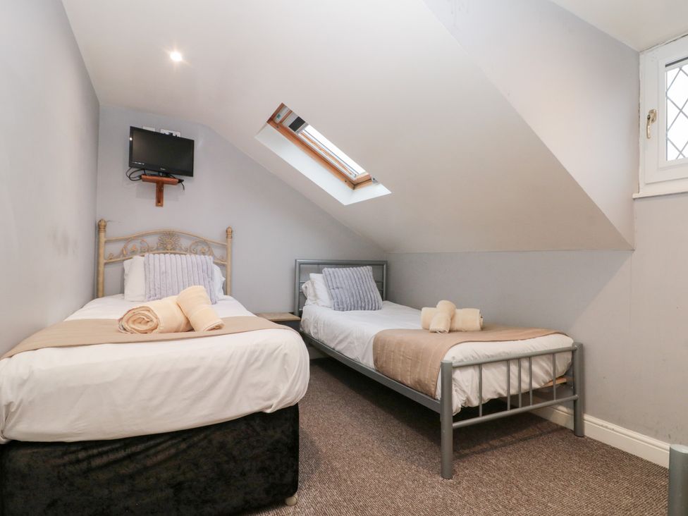 A bedroom with two single beds and a television at Seacrest Lodge in Scarborough
