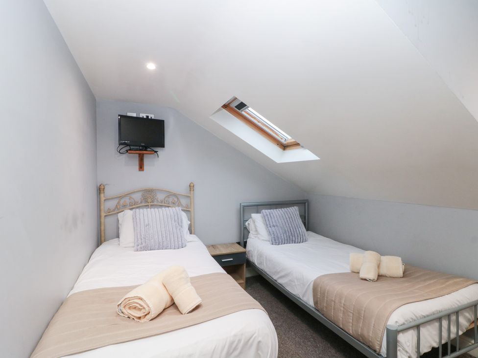 A bedroom with two single beds and a television at Seacrest Lodge in Scarborough