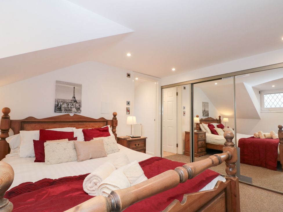 A bedroom with a wooden bed and wardrobe at Seacrest Lodge in Scarborough