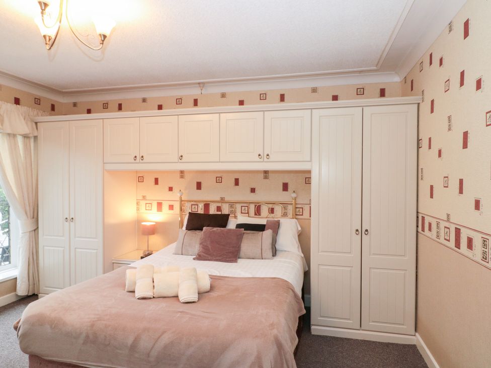 A bedroom with a bed and a wardrobe at Seacrest Lodge in Scarborough