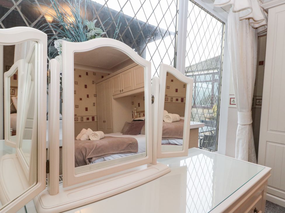 A bedroom with a dresser and mirror at Seacrest Lodge in Scarborough
