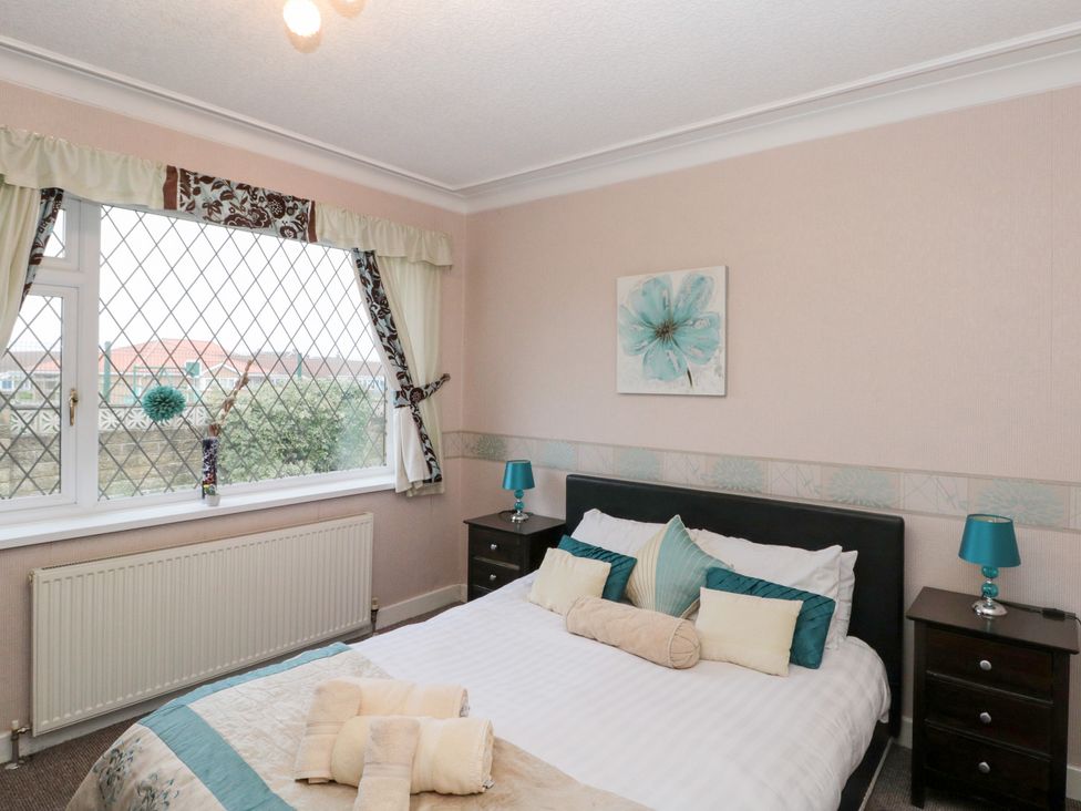 A bedroom with a bed and nightstands at Seacrest Lodge in Scarborough