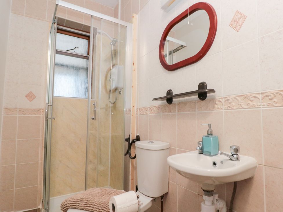 A bathroom with a shower, toilet, and sink at Seacrest Lodge in Scarborough