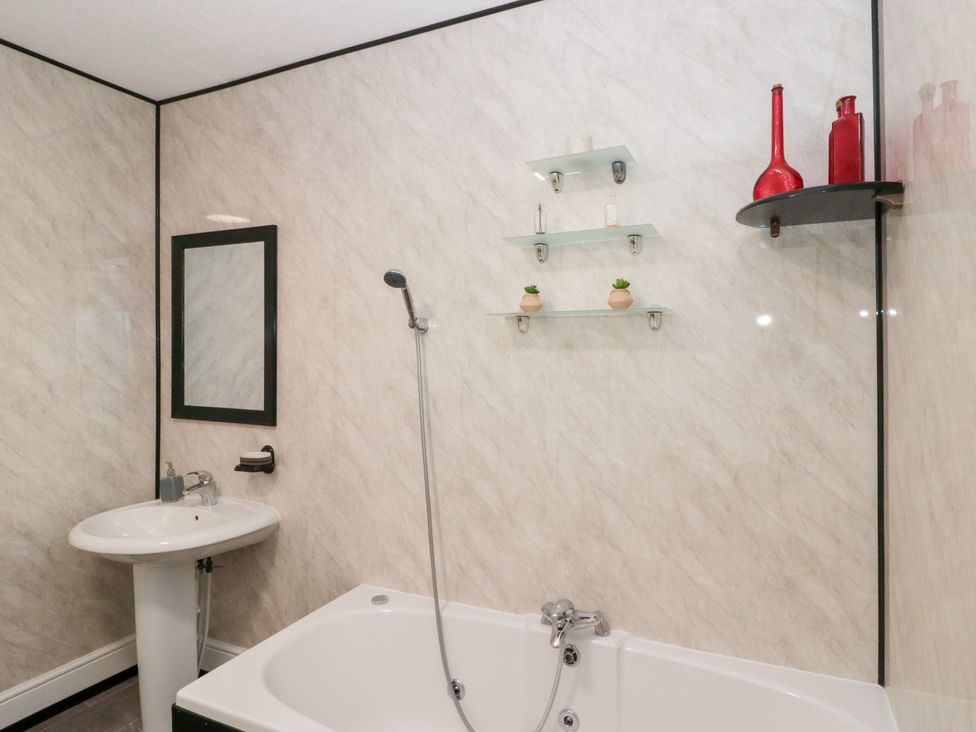 A bathroom with a bathtub and sink at Seacrest Lodge in Scarborough