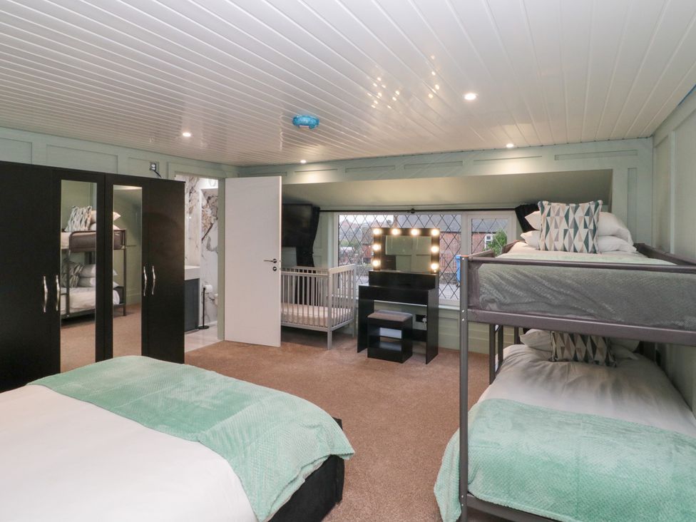 A bedroom with a bed, bunk bed, crib, and wardrobe at Seacrest Lodge in Scarborough