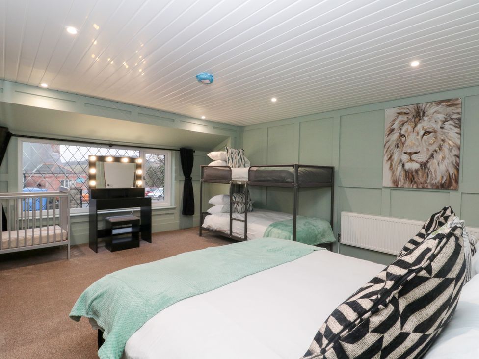 A bedroom with beds and a mirror at Seacrest Lodge in Scarborough