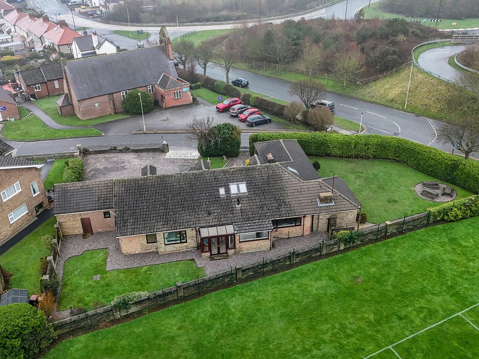 An outdoor view of a house with a garden and parking area at Seacrest Lodge in Scarborough