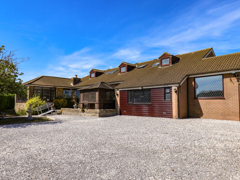 A house with a gravel driveway and porch at Seacrest Lodge in Scarborough