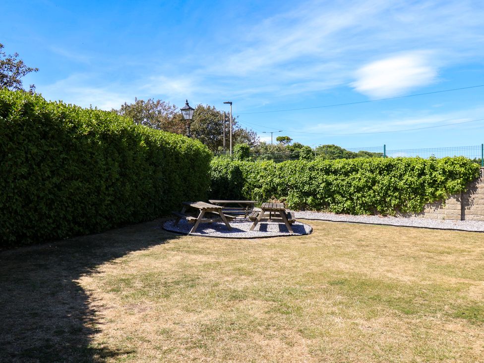 A garden with a picnic table and benches at Seacrest Lodge in Scarborough