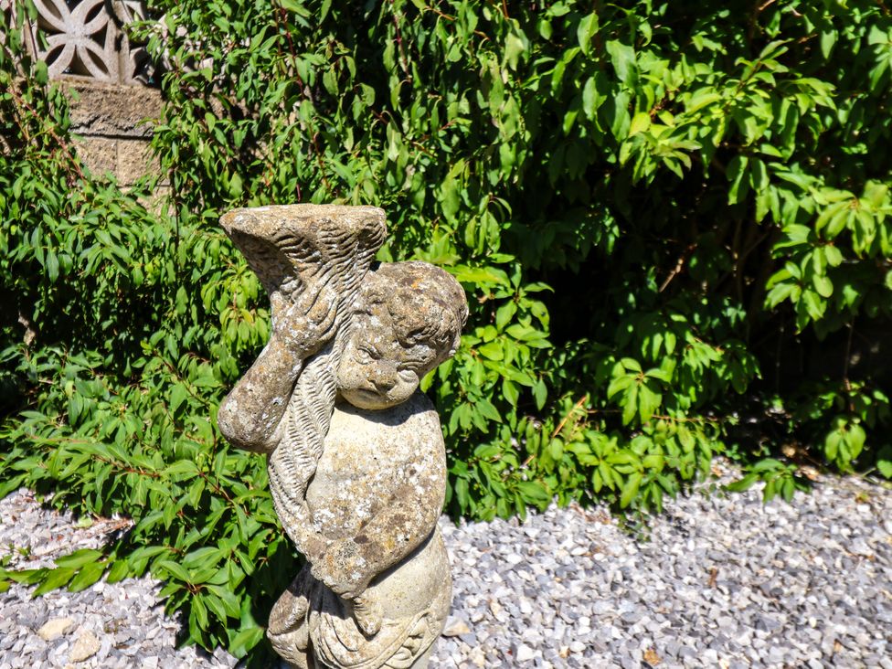 A statue of a child holding a horn in a garden at Seacrest Lodge Scarborough