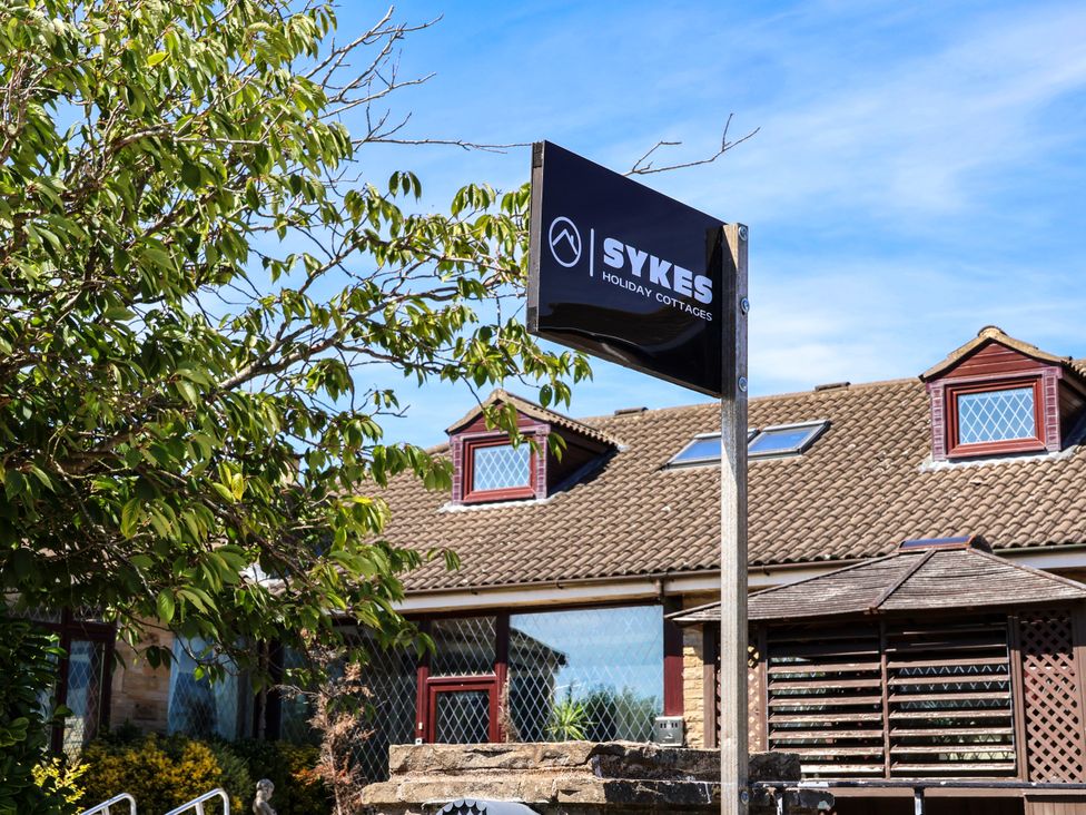A sign for Sykes Holiday Cottages outside a building in Scarborough
