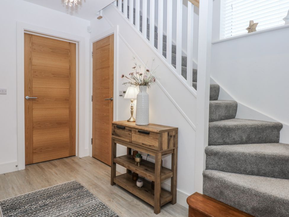 A hallway with a table and lamp at Estuary View in Colwyn Bay