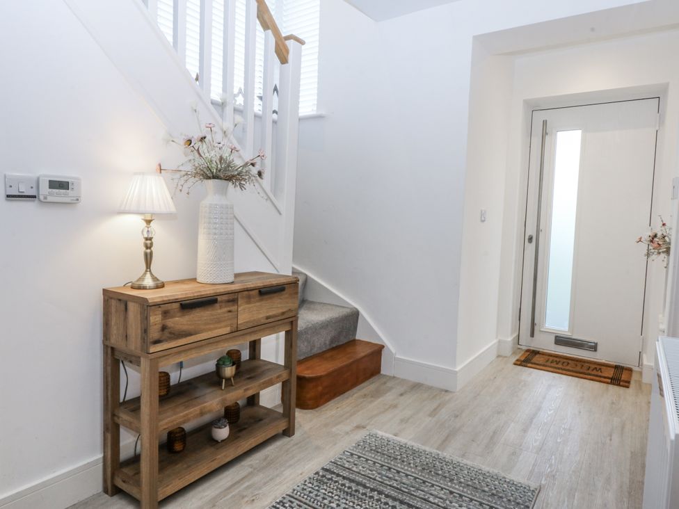 A hallway with a console table and lamp at Estuary View in Colwyn Bay