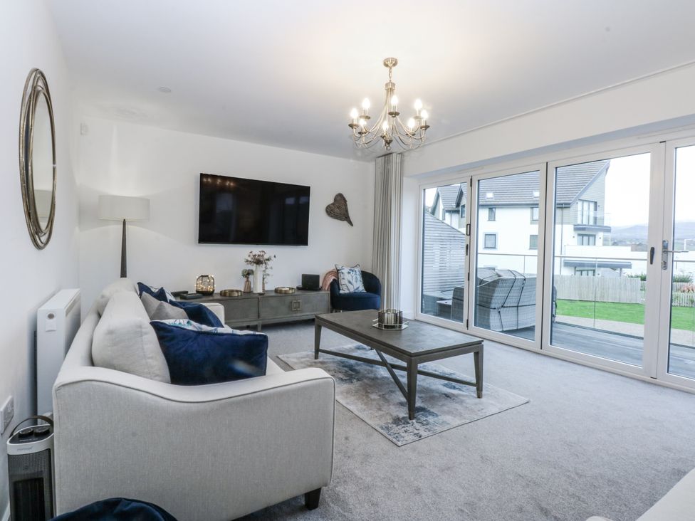 A living room with a television and sofa at Estuary View in Colwyn Bay