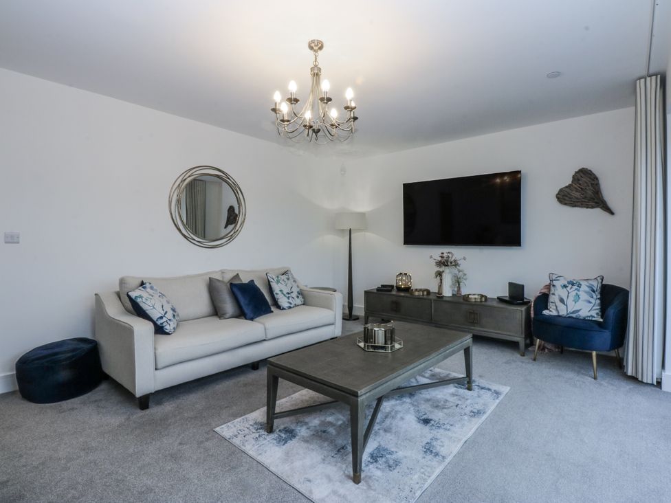 A living room with a sofa and television at Estuary View in Colwyn Bay
