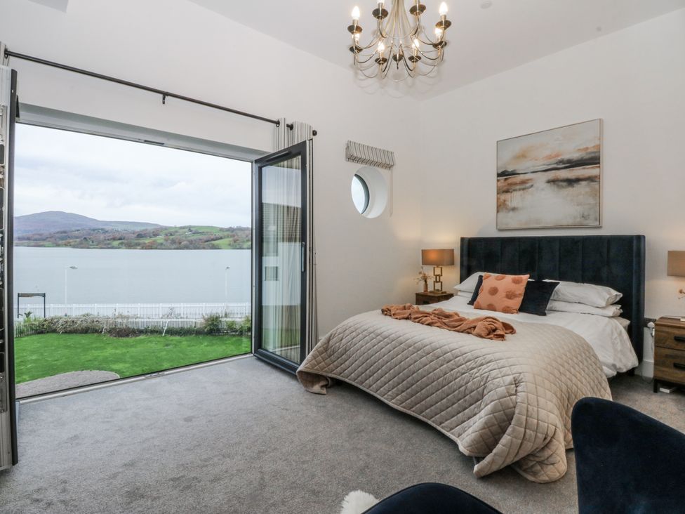 A bedroom with a bed and nightstands at Estuary View in Colwyn Bay