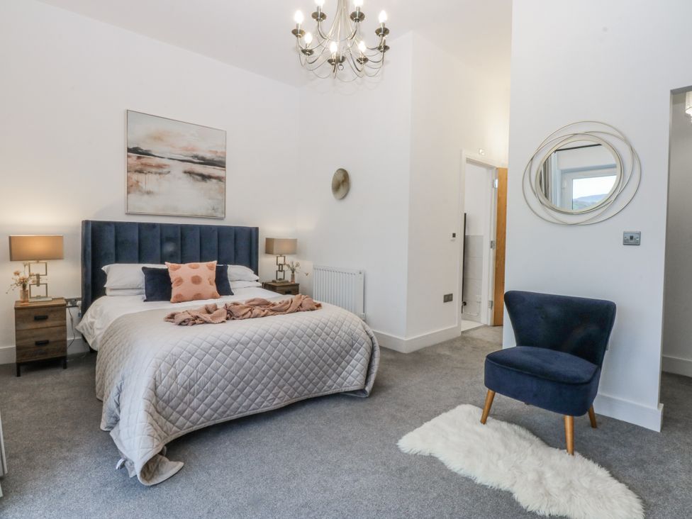 A bedroom with a bed and a chair at Estuary View in Colwyn Bay