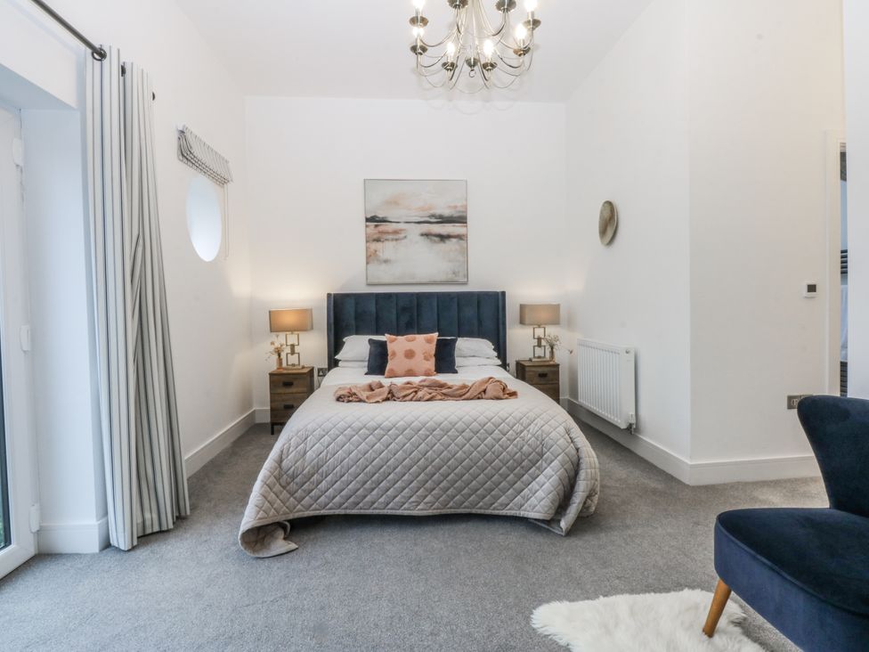 A bedroom with a bed and nightstand at Estuary View in Colwyn Bay