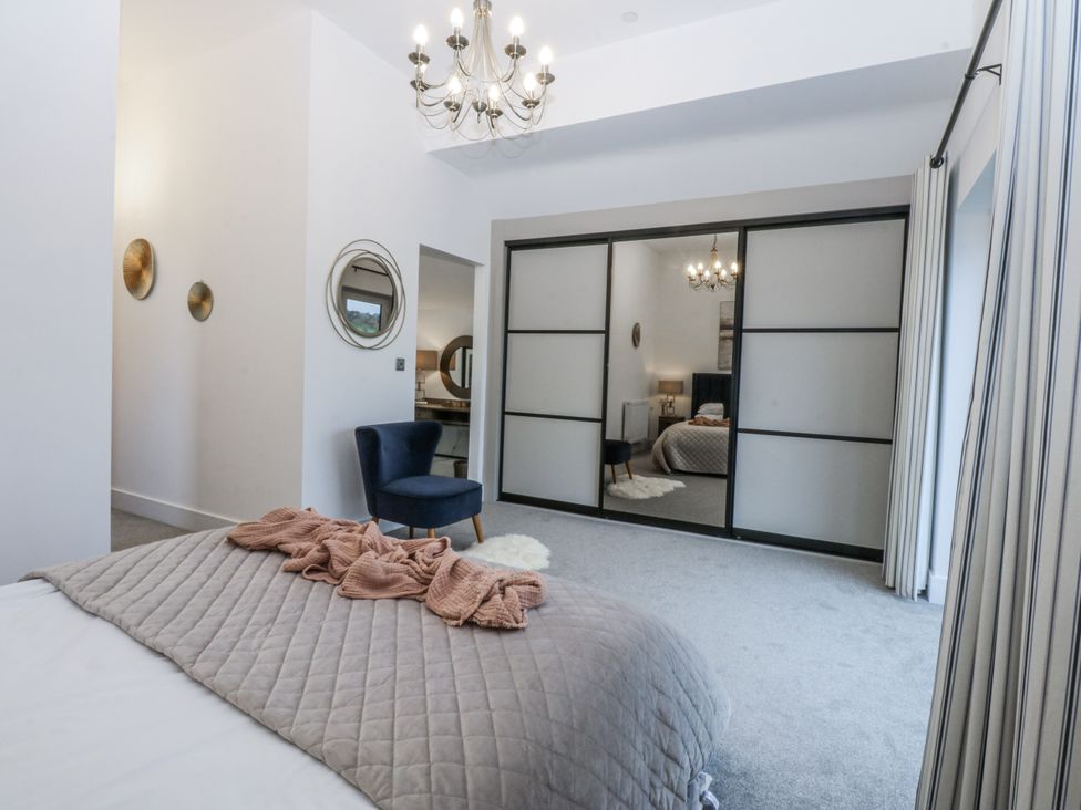 A bedroom with a bed and wardrobe at Estuary View in Colwyn Bay