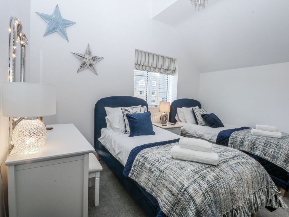 A bedroom with twin beds and a lamp at Estuary View in Colwyn Bay