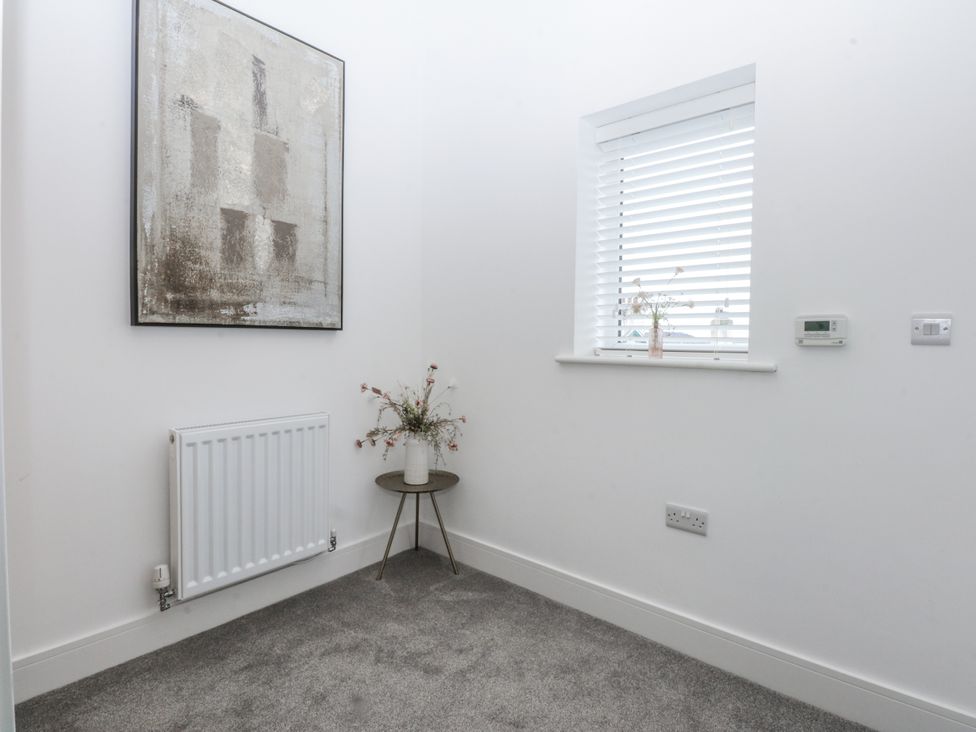 A small room with a table and a vase at Estuary View in Colwyn Bay