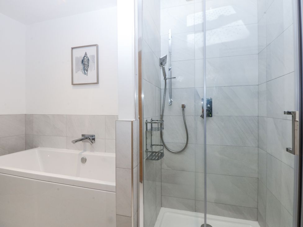 A bathroom with a bathtub and shower at Estuary View in Colwyn Bay