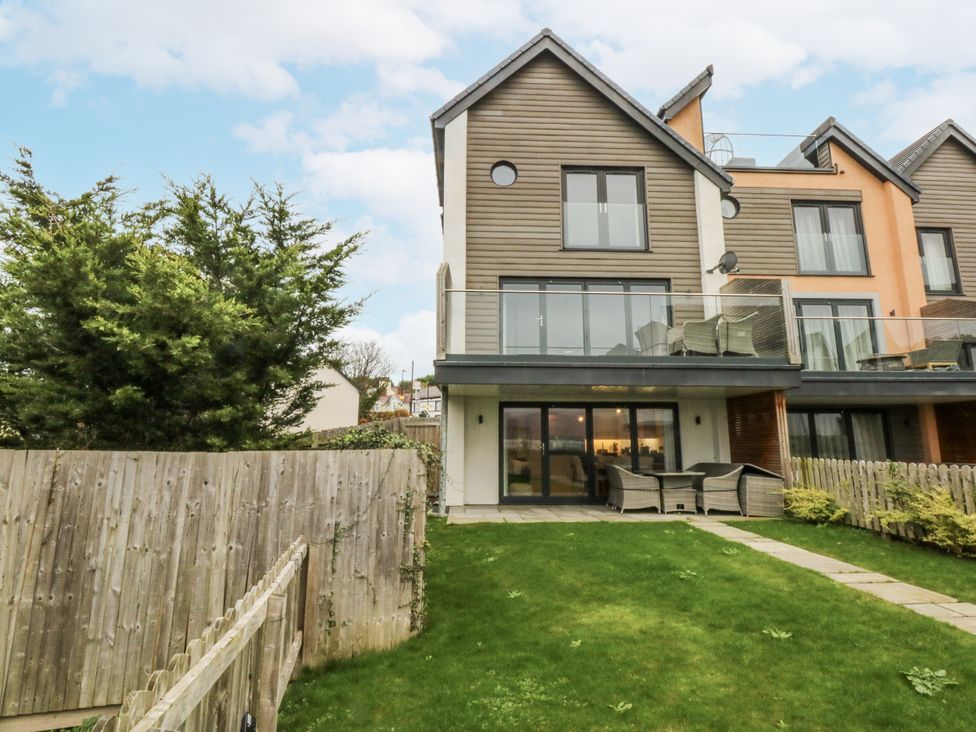 A garden with a house and patio furniture at Estuary View in Colwyn Bay